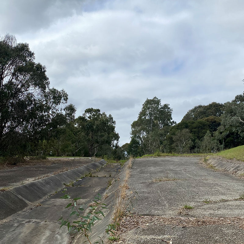 Before: Concreted area with shallow channel running through it