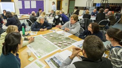 image of advisory group talking at table with maps