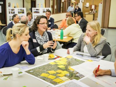 Women from Tarralla Creek Community Advisory Group sitting at tables with maps